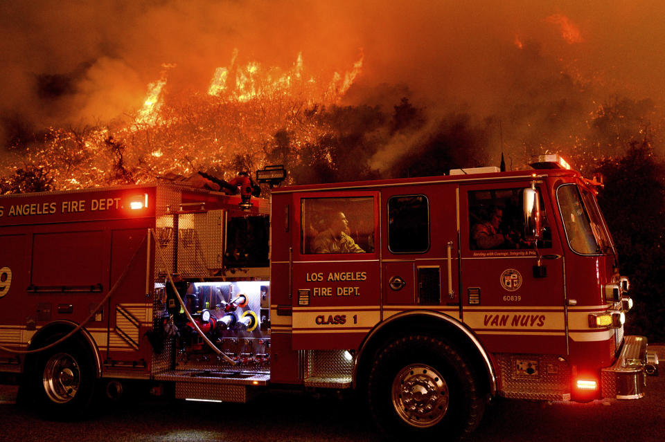 FILE - In this Nov. 26, 2019, file photo a firefighter prepares to battle the Cave Fire as it flares up along Highway 154 in the Los Padres National Forest, above Santa Barbara, Calif. As wildfire risks heat up, startups in California’s Silicon Valley are starting to take notice. They are hopeful more tech companies will get involved as wildfires continue to occur in California and Australia. (AP Photo/Noah Berger, File)