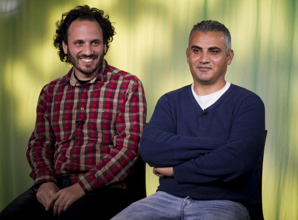 In this Tues., Feb. 5, 2013 photo, documentary film Co-directors, Israeli, Guy Davidi, left, and Palestinian, Emad Burnat, pose for a photo after an interview in Los Angeles. Their 2011 documentary film, “5 Broken Cameras,” is nominated for an Oscar in the best Documentary Feature category. (AP Photo/Damian Dovarganes)