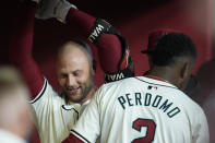 Arizona Diamondbacks' Christian Walker, left, smiles as he celebrates his home run against the Colorado Rockies with Diamondbacks' Geraldo Perdomo during the first inning of a baseball game Friday, March 29, 2024, in Phoenix. (AP Photo/Ross D. Franklin)