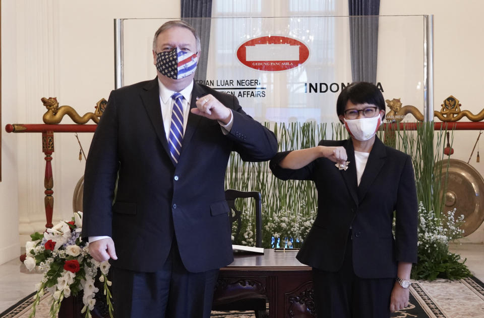 In this photo released by Indonesian Ministry of Foreign Affairs, U.S. Secretary of State Mike Pompeo, left, and Indonesian Foreign Minister Retno Marsudi pose for photographers during their meeting in Jakarta, Indonesia, Thursday, Oct. 29, 2020. Pompeo renewed the Trump administration's rhetorical onslaught against China in Indonesia on Thursday as the American presidential election looms. (Indonesian Ministry of Foreign Affairs via AP)