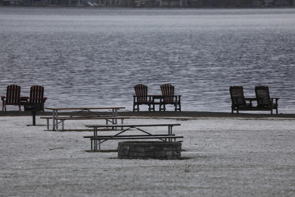 A dusting of snow sits on the grass at Onanda Park in Canandaigua. Chairs that have been left out face Canandaigua Lake.