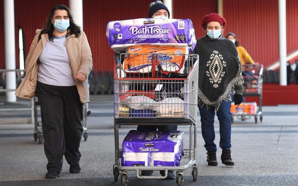 People push their trolleys outside a Costco outlet in Melbourne on Sunday - WILLIAM WEST/AFP