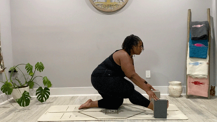 Woman on a yoga mat practicing half splits