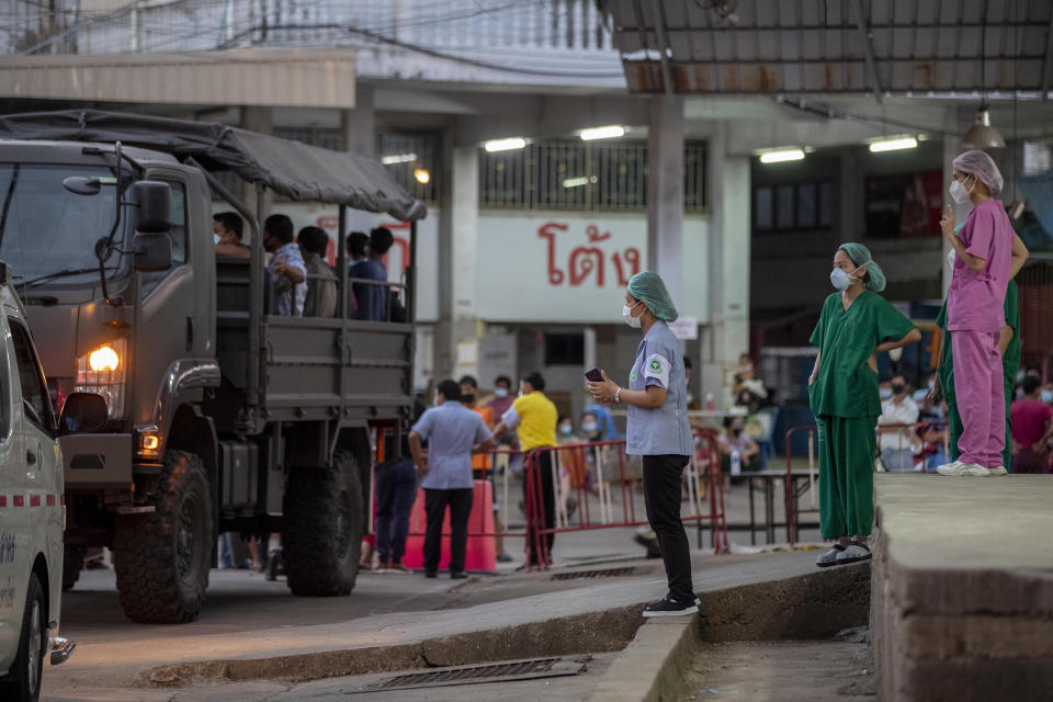 Medical workers watch as migrant workers and their families are prepared to be taken to a field hospital for COVID-19 patents in Samut Sakhon, South of Bangkok, Thailand, Monday, Jan. 4, 2021. For much of 2020, Thailand had the coronavirus under control. After a strict nationwide lockdown in April and May, the number of new local infections dropped to zero, where they remained for the next six months. However, a new outbreak discovered in mid-December threatens to put Thailand back where it was in the toughest days of early 2020. (AP Photo/Gemunu Amarasinghe)