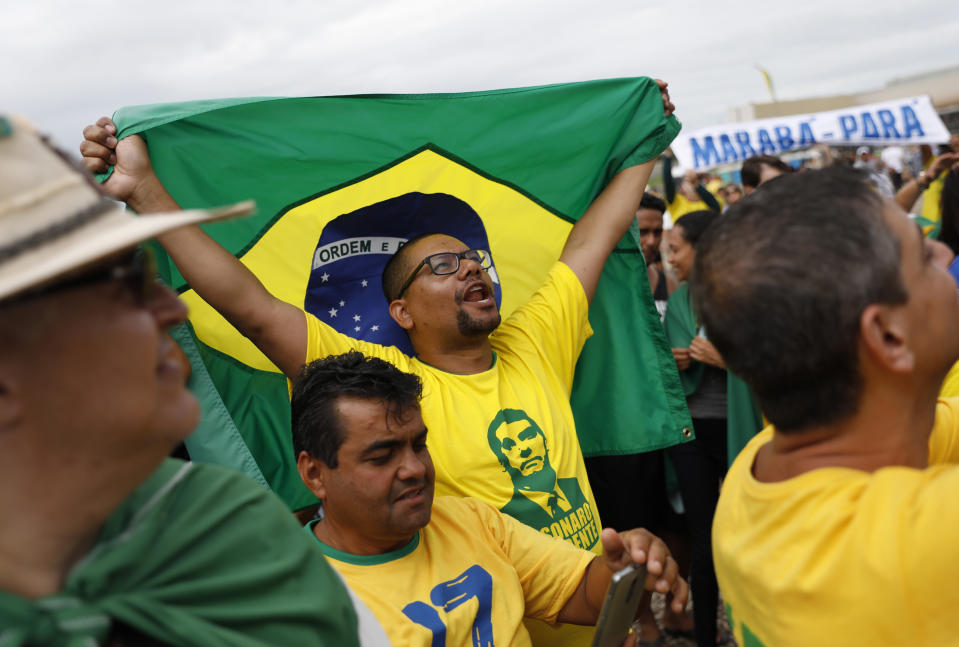 People celebrate before the swearing-in ceremony of Brazil's new President Jair Bolsonaro, in front of the Planalto palace in Brasilia, Brazil, Tuesday Jan. 1, 2019. (AP Photo/Silvia Izquierdo)