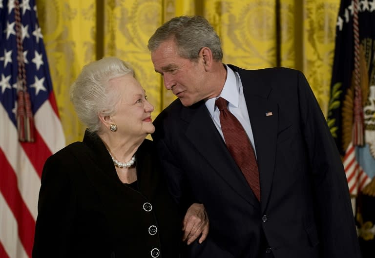 US president George W. Bush (R) presents the National Medals of Arts to actress Olivia de Havilland in 2008 in the East Room of the White House