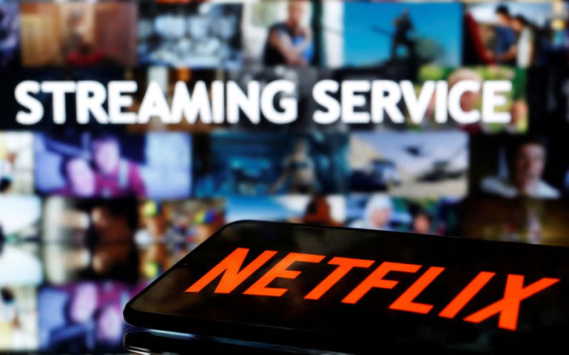 FILE PHOTO: A smartphone with the Netflix logo lies in front of the displayed words "Streaming service" in this illustration