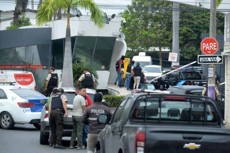 Miembros de la policía ecuatoriana toman posiciones afuera de las instalaciones del canal de televisión TC de Ecuador