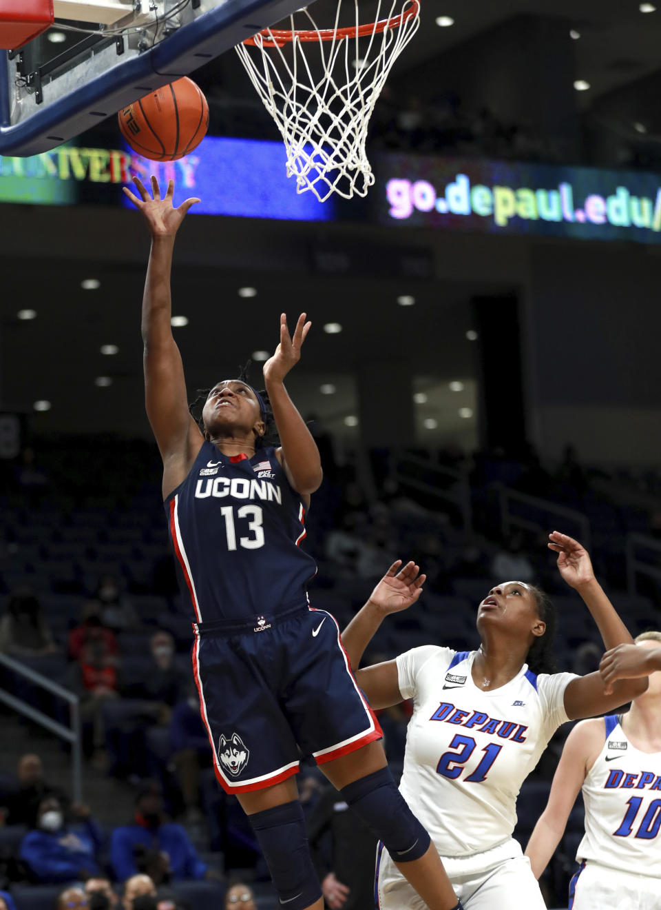 Connecticut guard Christyn Williams (13) drives to the hoop past DePaul guard Darrione Rogers (21) in the first half of an NCAA college basketball game at Wintrust Arena in Chicago on Wednesday, Jan. 26, 2022. (Chris Sweda/Chicago Tribune via AP)