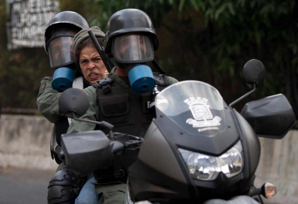 Un manifestante es arrestado por los soldados de la Guardia Nacional Bolivariana durante los enfrentamientos en una protesta contra el gobierno en Caracas, Venezuela, el sábado 26 de abril de 2014. (Foto AP/Fernando Llano)