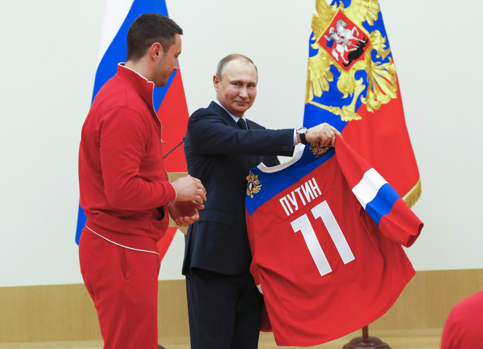 Russian President Vladimir Putin, receives a jersey from ice hockey player Ilya Kovalchuk, left, during a meeting with the Russian athletes who will take part in the upcoming 2018 Winter Olympic Games. (Grigory Dukor/Pool Photo via AP)