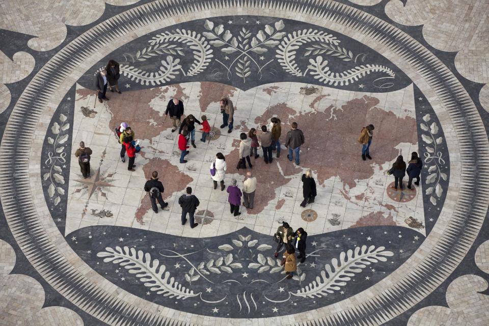 In this photo taken Dec. 26 2012, people look at a map of the world in Lisbon's Belem neighborhood at the Padrao dos Descobrimentos, or Monument to the Discoveries, that celebrate's Portugal's 15th and 16th century Age of Discovery. The map decorates the center of a marble wind rose offered to Portugal by South Africa. (AP Photo/Armando Franca)