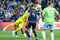 Vancouver Whitecaps goalkeeper Yohei Takaoka, in yellow, punches the ball away from Seattle Sounders forward Raúl Ruidíaz, second from right, as forward Jordan Morris (13) and Whitecaps defender Ranko Veselinovic (4) watch during the first half of an MLS soccer match Saturday, April 20, 2024, in Seattle. (AP Photo/Lindsey Wasson)