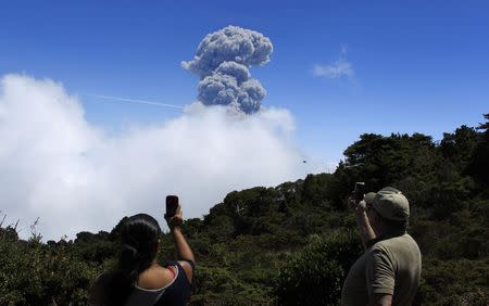 People take pictures of an eruption of the Turrialba volcano, from San Gerardo de Irazu near Turrialba, March 13, 2015. REUTERS/Juan Carlos Ulate