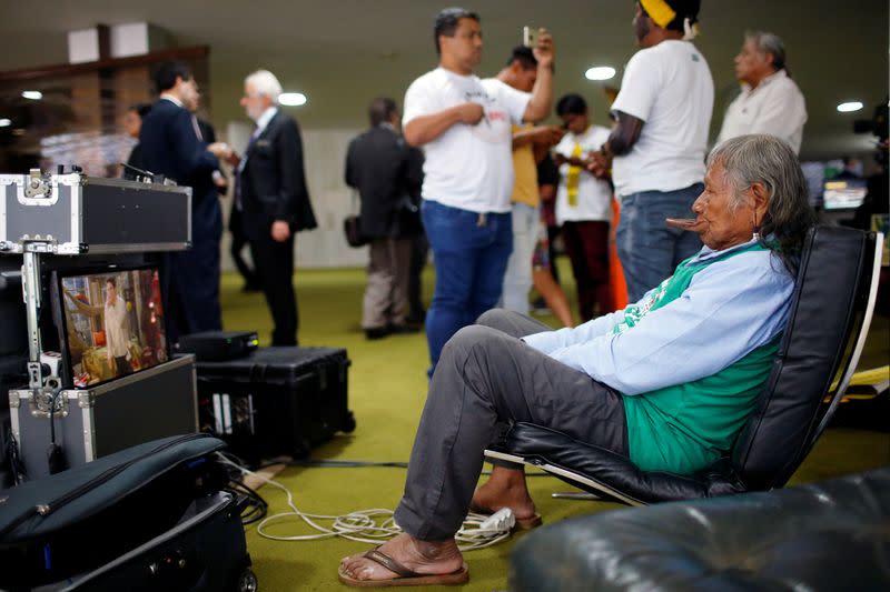 Brazil's indigenous chief Raoni Metuktire watches TV after a meeting with the parliamentary front in defense of the rights of indigenous people in Brasilia