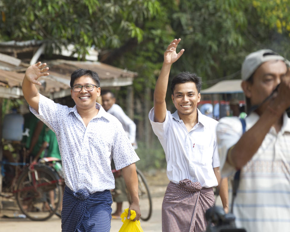 Reuters journalists Wa Lone, left, and Kyaw She Oo, right, wave as they walk out from Insein Prison after being released in Yangon, Myanmar Tuesday, May 7, 2019. The chief of the prison said two Reuters journalists who were imprisoned for breaking the country's Officials Secrets Act have been released. (AP Photo/Thein Zaw)