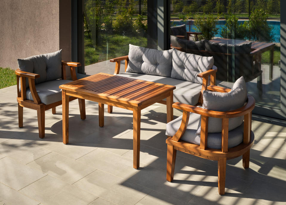A patio with wooden outdoor table and chairs