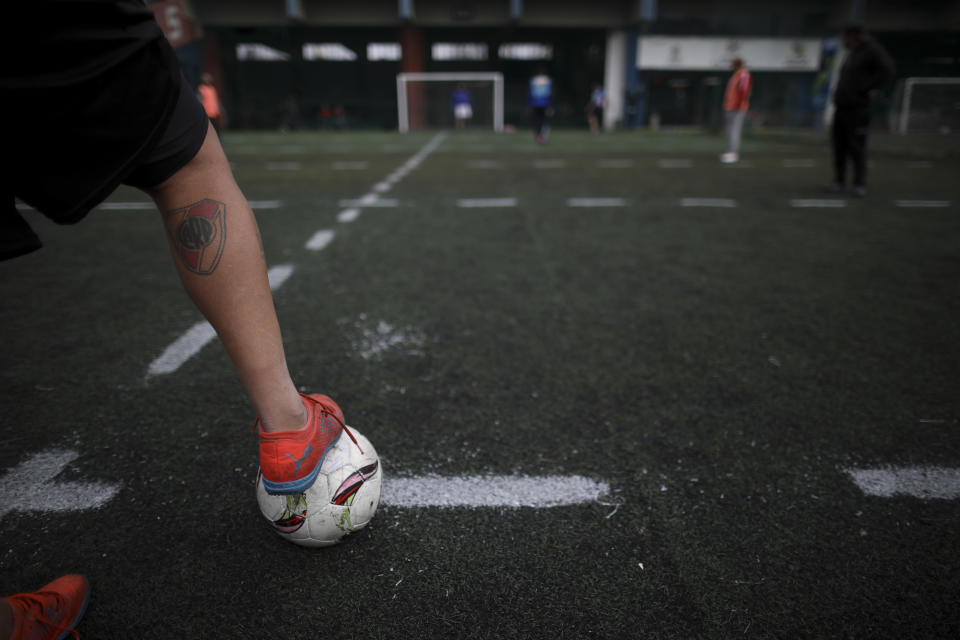 A player steps on the ball during an amateur soccer match at a local club, Play Futbol 5, in Pergamino, Argentina, Wednesday, July 1, 2020. In order to continue playing amid government restrictions to curb the spread of the new coronavirus, the club divided its soccer field into 12 rectangles to mark limited areas for each player, keeping them from making physical contact. (AP Photo/Natacha Pisarenko)