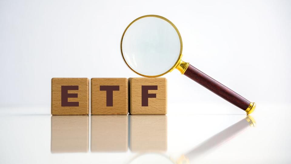 Blocks with the letters ETF on which a magnifying glass lies.