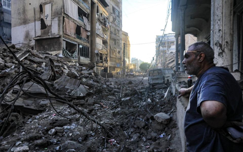 A resident stares at the destruction in the aftermath of an Israeli strike on the neighbourhood of Mreijeh in Beirut's southern suburbs