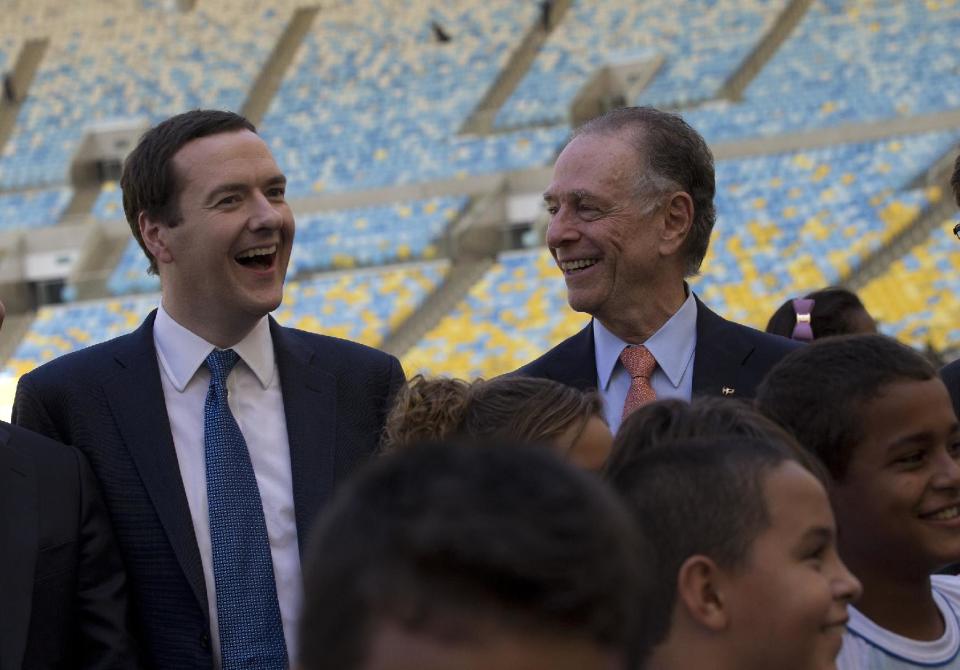 Britain's Chancellor of the Exchequer George Osborne, left, and President of Brazil's Olympic Committee Carlos Arthur Nuzman smile as they pose for a photo during a visit to the Maracana stadium in Rio de Janeiro, Brazil, Monday, April 7, 2014. The city of Rio de Janeiro will host the Olympics in 2016. (AP Photo/Silvia Izquierdo)