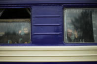 A child and a man, fleeing from heavy shelling, wave to the photographer before departing in an evacuation train at Pokrovsk train station, in Pokrovsk, eastern Ukraine, Sunday, May 22, 2022. Civilians fleeing areas near the eastern front in the war in Ukraine Sunday described scenes of devastation as their towns and villages came under sustained attack from Russian forces. (AP Photo/Francisco Seco)