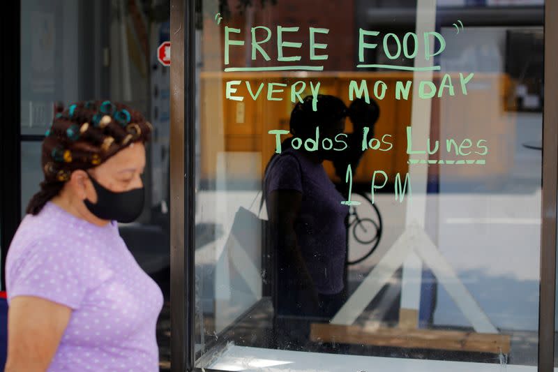 FILE PHOTO: A pedestrian passes a notice for a food pantry in Chelsea
