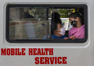 Children wearing masks to protect themselves against the coronavirus wait inside an ambulance for anti-rabies vaccine shots in Dharmsala, India, Thursday, Oct. 29, 2020. India’s confirmed coronavirus caseload surpassed 8 million on Thursday with daily infections dipping to the lowest level this week, as concerns grew over a major Hindu festival season and winter setting in. (AP Photo/Ashwini Bhatia)