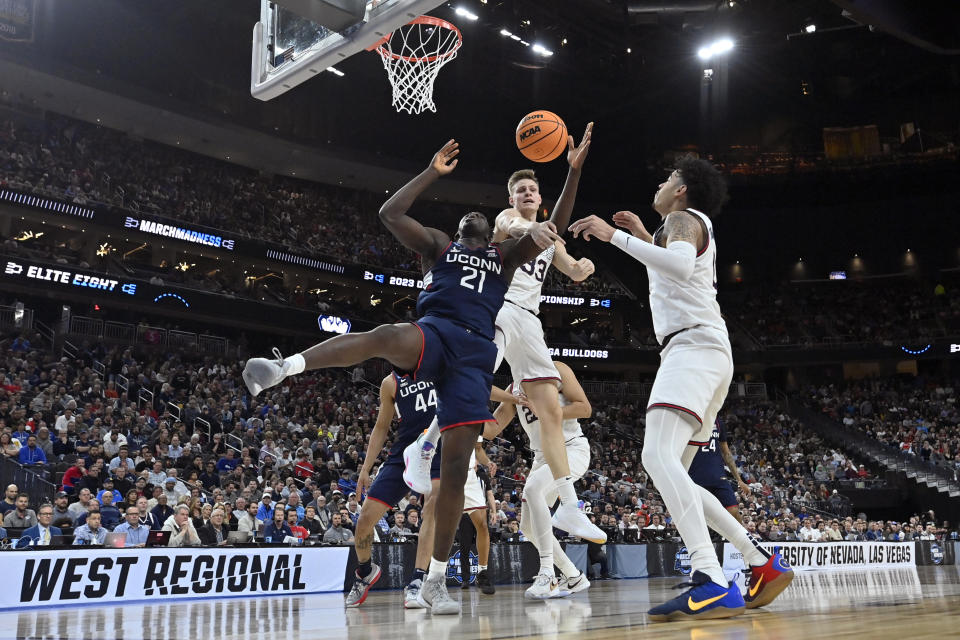 UConn forward Adama Sanogo (21) and Gonzaga forward Ben Gregg, middle, battle for the ball in the first half of an Elite 8 college basketball game in the West Region final of the NCAA Tournament, Saturday, March 25, 2023, in Las Vegas. (AP Photo/David Becker)
