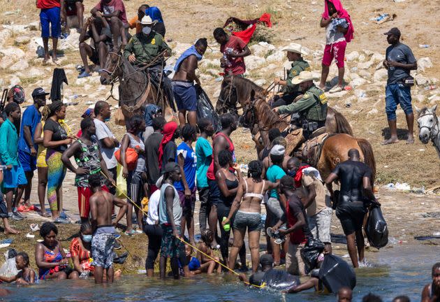 US border patrol agents interact with Haitian immigrants on the bank of the Rio Grande in Del Rio, Texas on Monday (Photo: John Moore via Getty Images)