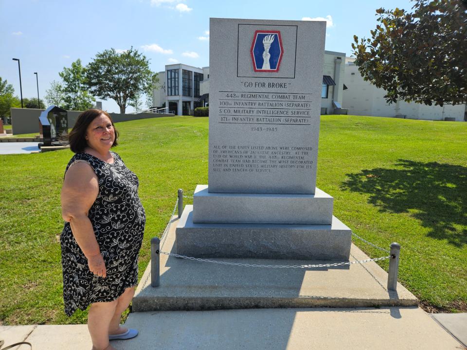 Hattiesburg American reporter Lici Beveridge stands at the memorial for the 442nd Regimented Combat Troops and the 100th Infantry Battalion honoring Japanese American soldiers who fought during World War II, Wednesday, June 28, 2023. The memorial is outside the Mississippi Armed Forces Museum at Camp Shelby, near Hattiesburg, MIss.