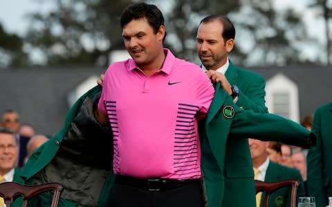 Patrick Reed receives the Green Jacket from last year's winner, Sergio Garcia - Credit: AP