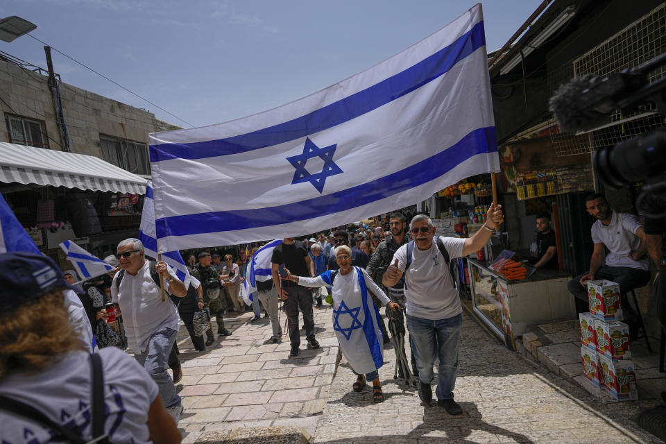 Israelis wave national flags ahead of a march marking Jerusalem Day, an Israeli holiday celebrating the capture of east Jerusalem in the 1967 Mideast war, in Jerusalem's Old City, Thursday, May 18, 2023. (AP Photo/Ohad Zwigenberg)