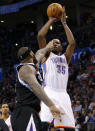 Oklahoma City Thunder forward Kevin Durant (35) shoots as Sacramento Kings center DeMarcus Cousins (15) defends in the third quarter of an NBA basketball game in Oklahoma City, Sunday, Jan. 19, 2014. Oklahoma City won 108-93. (AP Photo/Sue Ogrocki)