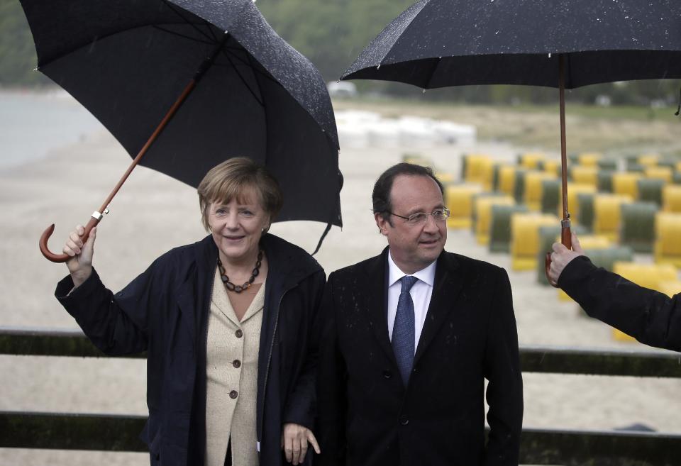 German Chancellor Angela Merkel, left, and the President of France, Francois Hollande, right, pose for the media during a visit to the baltic sea island of Ruegen, northern Germany, Friday, May 9, 2014. Merkel and Hollande meet for two days on the island of Ruegen and in the coastal city of Stralsund. (AP Photo / Michael Sohn)