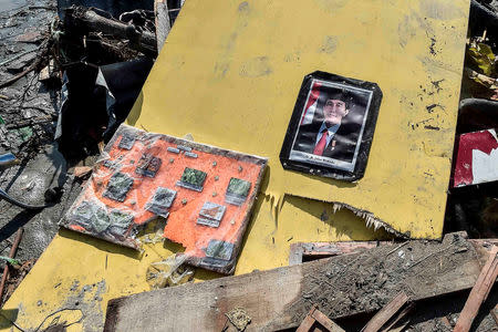 A portrait of Indonesia's President Joko Widodo is seen on a collapsed structure after an earthquake and tsunami hit in Palu, Central Sulawesi, Indonesia October 12, 2018, in this photo taken by Antara Foto. Antara Foto/Muhammad Adimaja/ via REUTERS