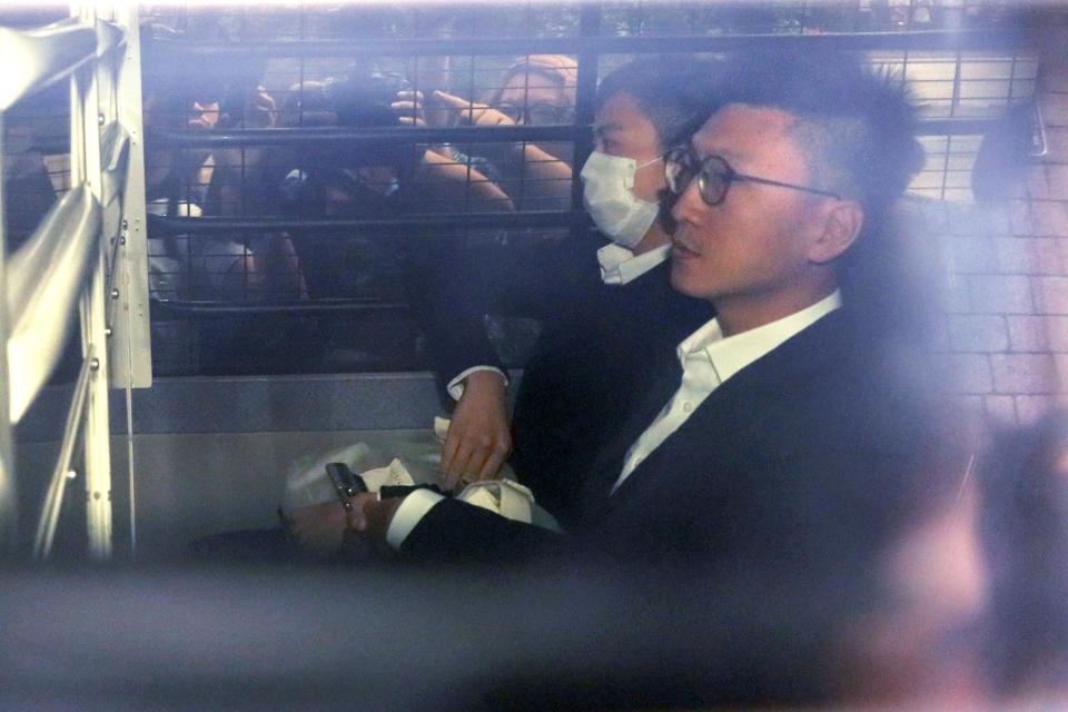 FILE - Hong Kong jailed activist Edward Leung, right, is escorted by Correctional Services officers in a prison van as he arrives at high court for his sentence appeal in Hong Kong, on Oct. 9, 2019. Leung, who coined the now-banned slogan "Liberate Hong Kong, Revolution of our Times," was released from prison Wednesday, Jan. 19, 2022, after spending four years behind bars for rioting in 2016. (AP Photo/Kin Cheung,File)