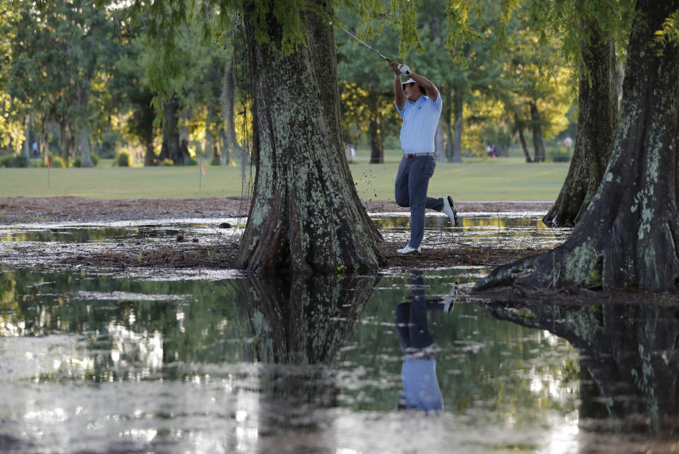 Danny Lee of New Zealand hits from between cypress trees off the 16th fairway, which was flooded from afternoon rains, during the first round of the PGA Zurich Classic golf tournament at TPC Louisiana in Avondale, La., Thursday, April 25, 2019. (AP Photo/Gerald Herbert)