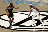 Brooklyn Nets guard James Harden, left, looks to pass around Milwaukee Bucks guard Jrue Holiday, right, during the first half of an NBA basketball game Monday, Jan. 18, 2021, in New York. (AP Photo/Adam Hunger)