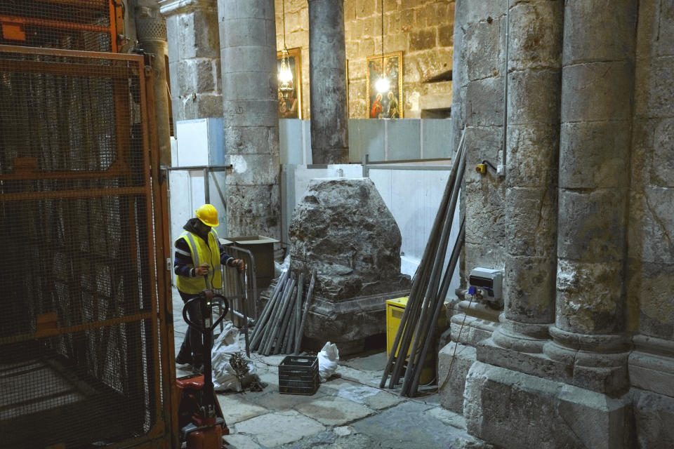 A member of the restoration team works on the floor of the Church of the Holy Sepulchre, where many Christians believe Jesus was crucified, buried and rose from the dead, in the Old City of Jerusalem, Thursday, March 17, 2022. The three Christian communities that have uneasily shared their holiest site for centuries are embarking on a project to restore the ancient stone floor of the Jerusalem basilica. The project includes an excavation that could shed light on the rich history of the Church of the Holy Sepulchre in the Old City. (AP Photo/Mahmoud Illean)