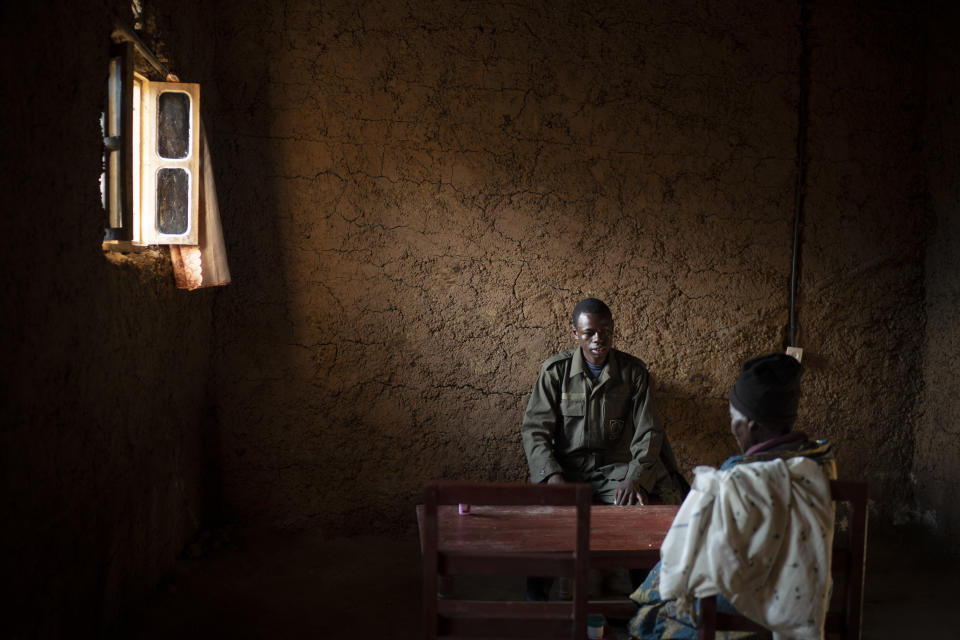 Jean Claude Masengesho, who earns extra money by helping tourists carry their bags up the mountain to see gorillas, sits with his mother in their home in Kinigi, Rwanda. (Photo: Felipe Dana/AP)