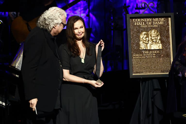 Ricky Skaggs le entrega a Ashley Judd el medallón que le habría dado a su madre Naomi Judd, quien murió inesperadamente un día antes, durante la Ceremonia de entrega de medallas en el Salón de la fama de la música country el domingo 1 de mayo de 2022 en Nashville, Tennessee ( Foto de Wade Payne/Invision/AP)