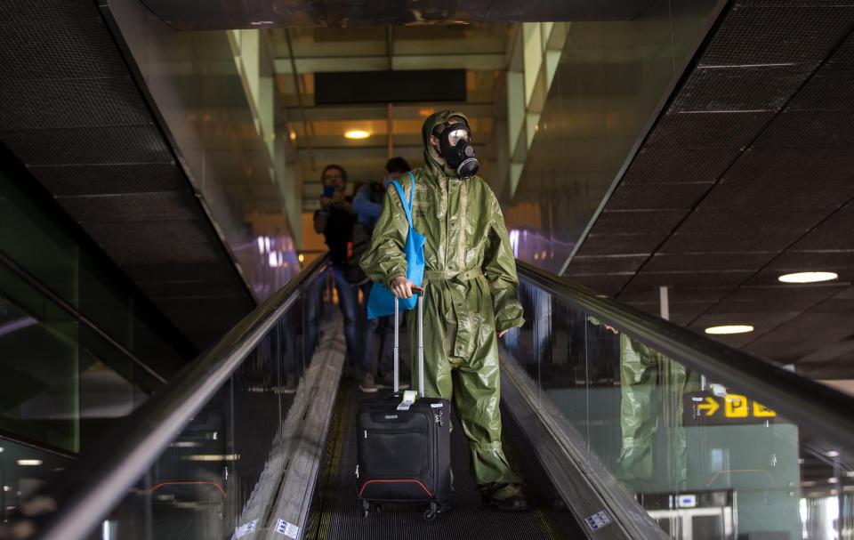 A passenger wearing a full protective suit arrives from London at the Barcelona airport, Spain, on Friday, May 15, 2020. Travellers arriving in Spain from overseas start from Friday going into a 14-day confinement as the country takes timid steps toward re-opening borders with eyes set on reactivating the crucial tourism industry. (AP Photo/Emilio Morenatti)