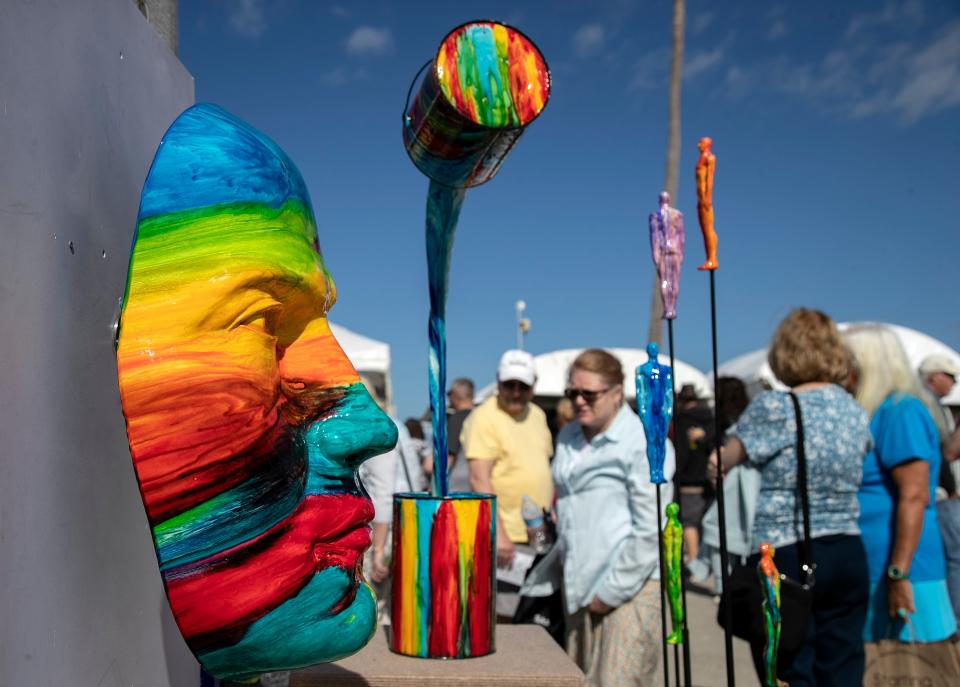 Shoppers at Art Fest Fort Myers look at the sculptures of Ancizar Marin on Saturday, Feb. 4, 2023, in downtown Fort Myers.