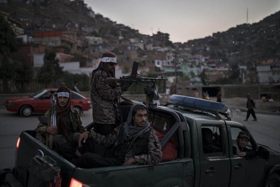 Taliban fighters sit on the back of a pickup truck as they stop on a hillside in Kabul, Afghanistan, Sunday, Sept. 19, 2021. (AP Photo/Felipe Dana)