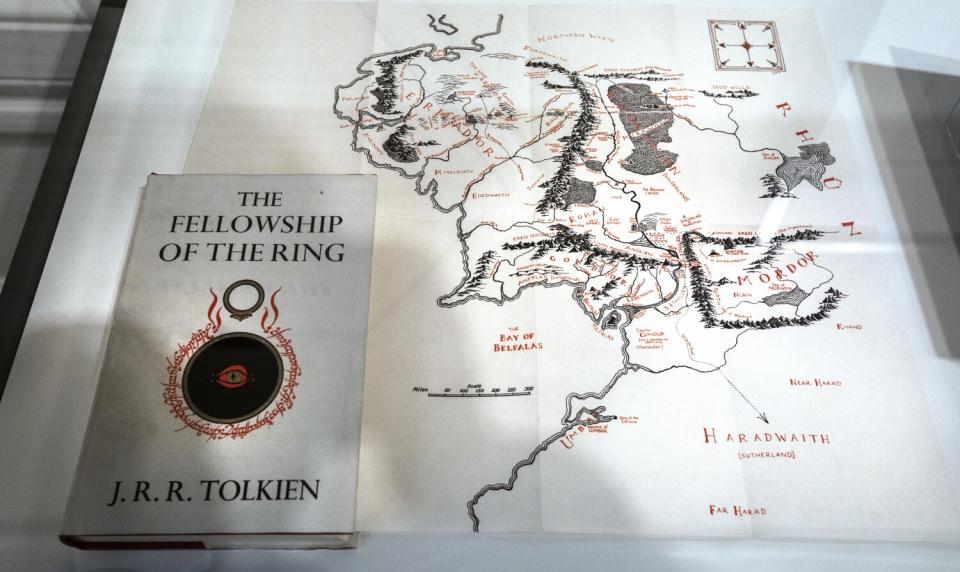 A framed map with a book titled "The Fellowship of The Ring" on top of it