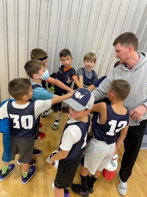 Noah Bruner huddles with a Little Dribblers basketball team he was coaching at Power2Play Sports in Windsor, where he worked as an operations assistant. Bruner, 21, was killed Sunday in a plane crash in Chadron, Nebraska, that also killed his father, who was piloting the plane, and his brother's girlfriend.