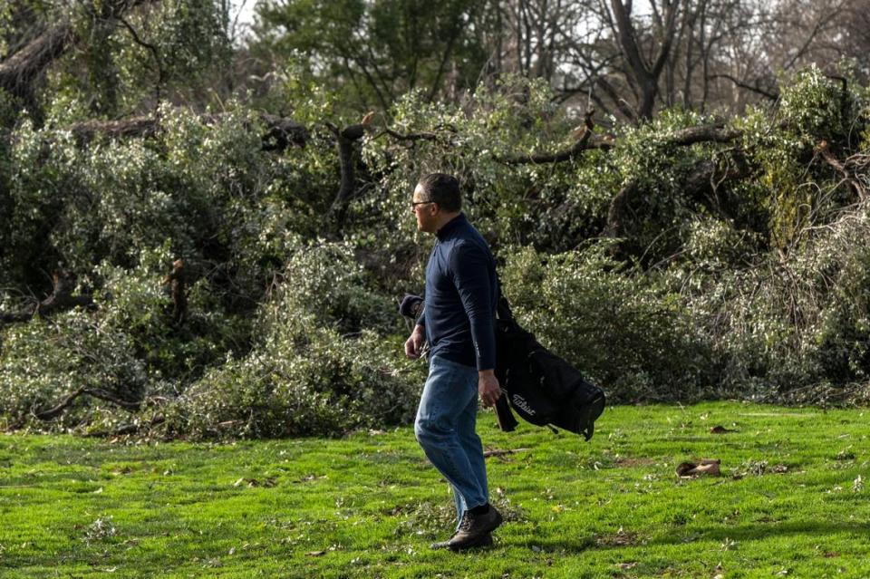 Nate Simon of Sacramento walks past fallen trees at William Land Golf Course in January after the course was battered by historic rainfall.