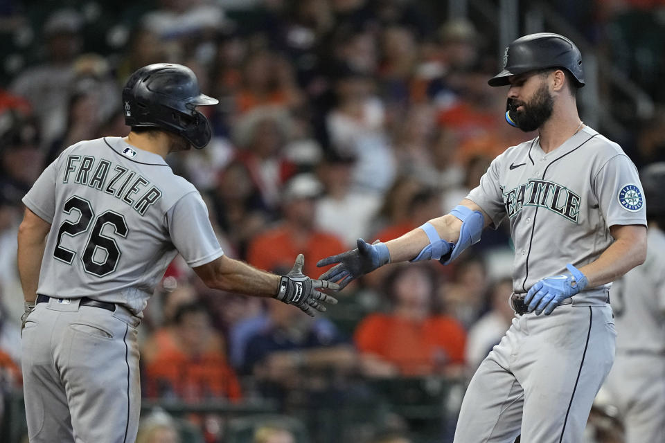 Seattle Mariners' Jesse Winker, right, celebrates with Adam Frazier (26) after both scored on Winker's two-run home run against the Houston Astros during the eighth inning of a baseball game Sunday, July 31, 2022, in Houston. (AP Photo/David J. Phillip)