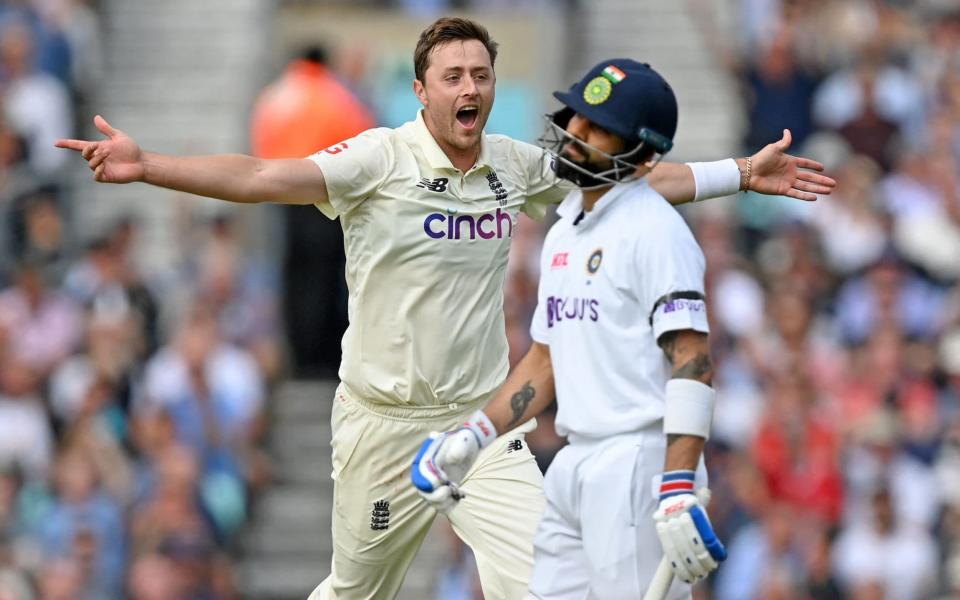 England's Ollie Robinson celebrates after taking the wicket of India's captain Virat Kohli (R) for 50 runs during play on the first day of the fourth cricket Test match between England and India at the Oval - DANIEL LEAL-OLIVAS/AFP via Getty Images